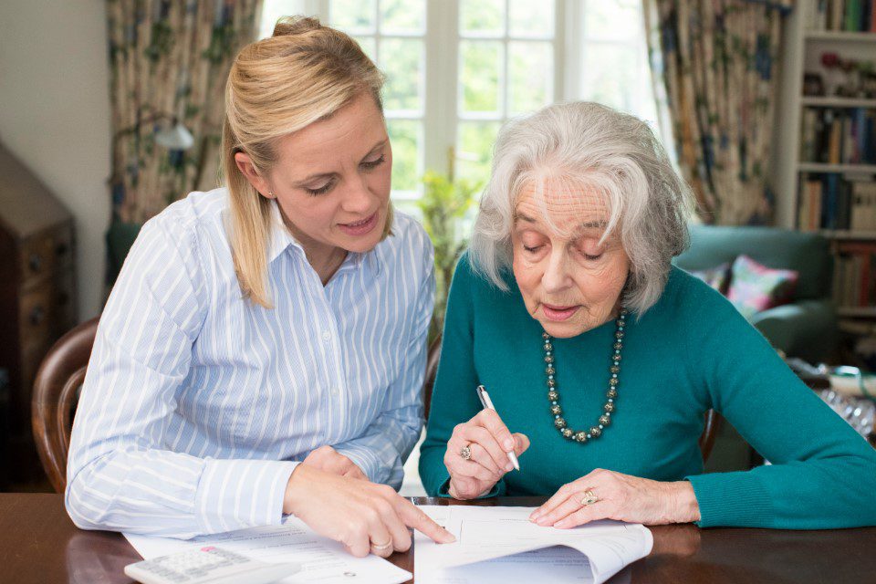 Woman signing power of attorney with her lawyer